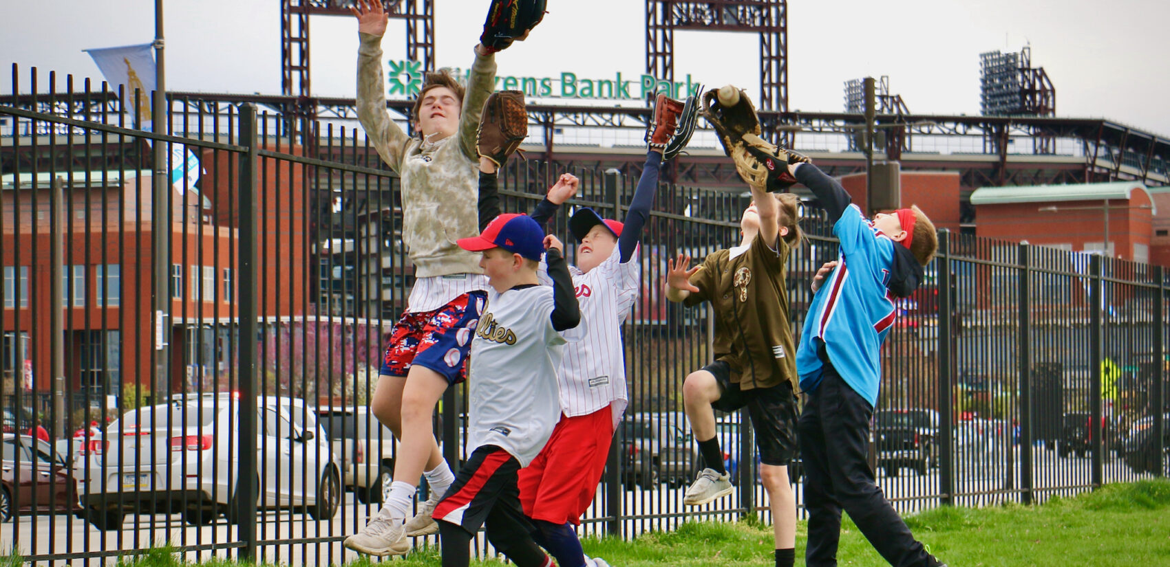 Children playing catch outside of the baseball stadium