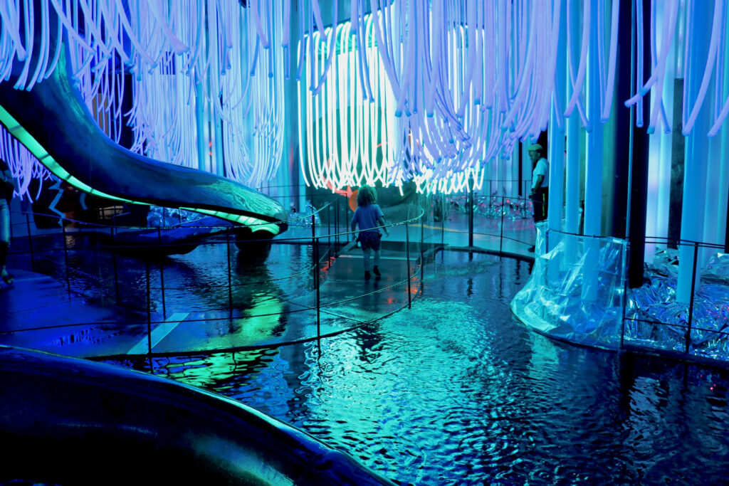 A child walking in an colorful immersive art exhibit.
