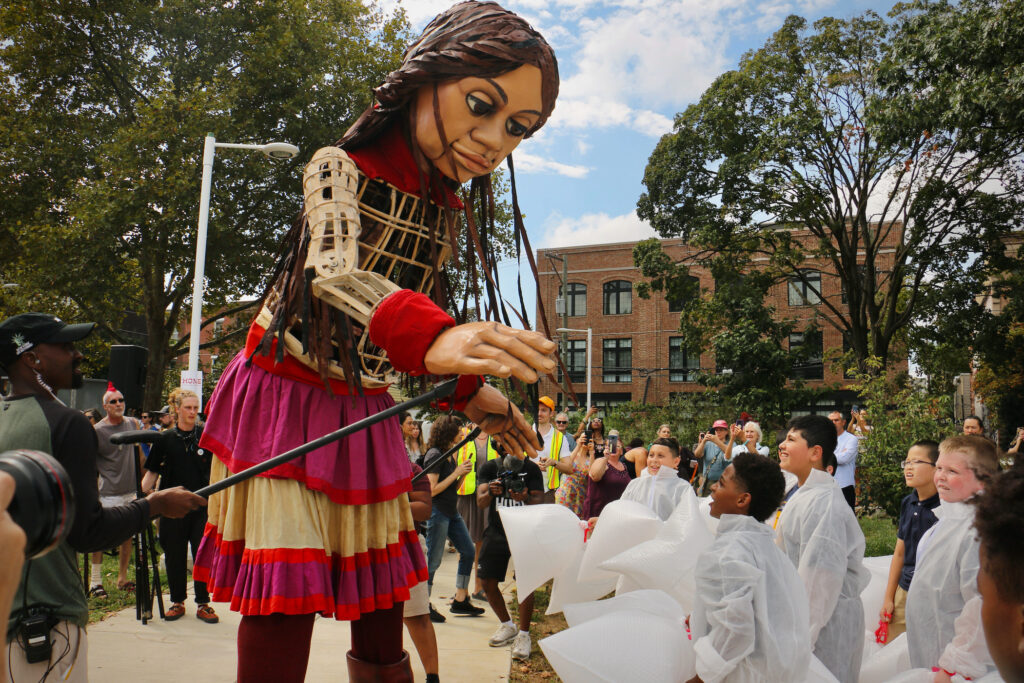 a 12-foot-tall puppet greets school children