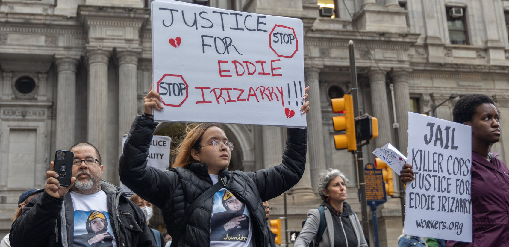 Maria Irizarry holds up a sign saying 'Justice for Eddie Irizarry!!!'