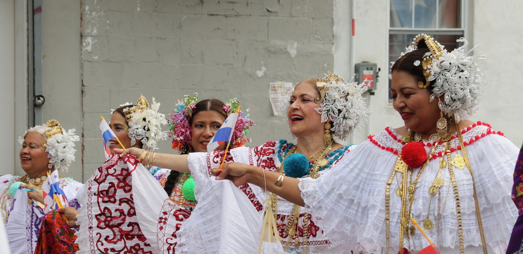 Women wearing traditional clothing sing and dance