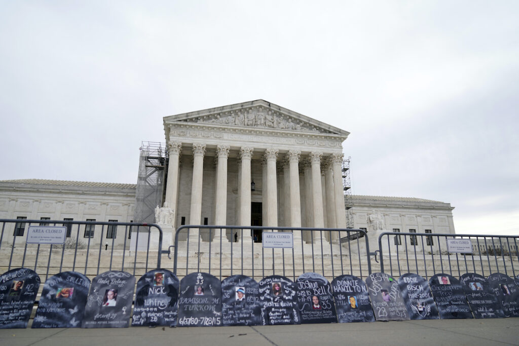 Supreme Court Opioid Crisis Purdue Pharma Signs in the shape of grave headstones, with information on people who died from using OxyContin, line a security fence outside the Supreme Court Monday, Dec. 4, 2023, in Washington.The Supreme Court is wrestling with a nationwide settlement with OxyContin maker Purdue Pharma that would shield members of the Sackler family who own the company from civil lawsuits over the toll of opioids. (AP Photo/Stephanie Scarbrough)