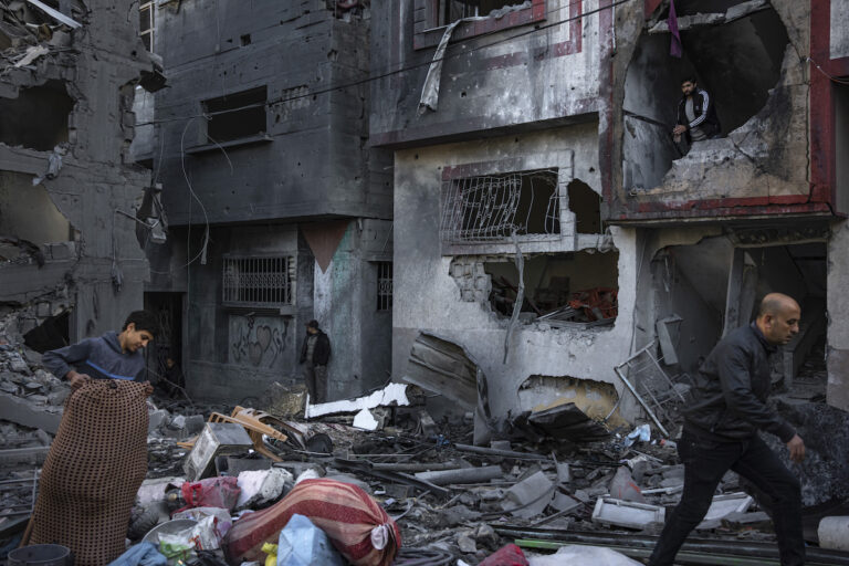 Palestinians look at houses destroyed in the Israeli bombardment of the Gaza Strip in Rafah on Saturday, Dec. 9, 2023.
