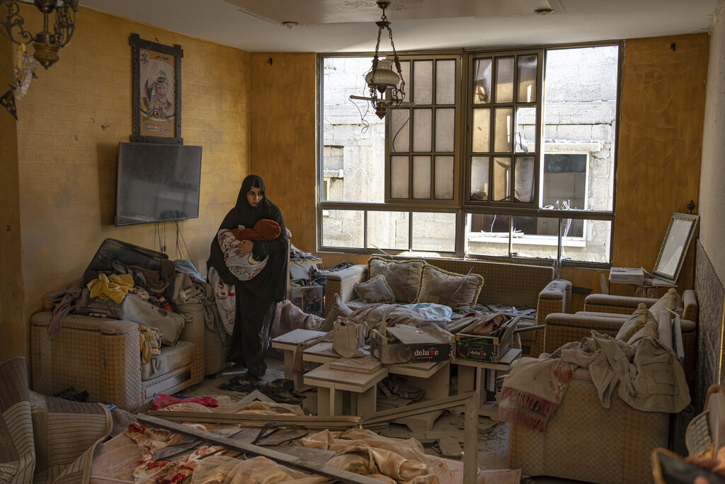 Israel Palestinians A Palestinian woman holds her child in a room