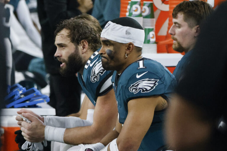 Philadelphia Eagles quarterback Jalen Hurts (1) sits with tight end Dallas Goedert, left, on the bench during the first half of an NFL football game against the Dallas Cowboys, Sunday, Dec. 10, 2023, in Arlington, Texas.