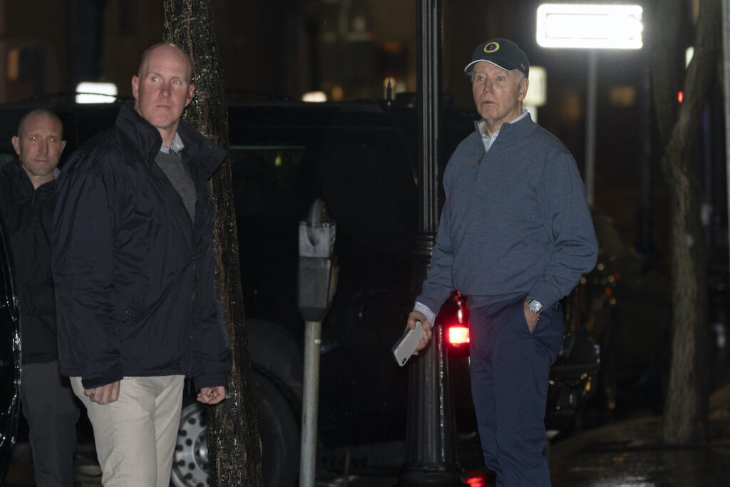 Joe Biden President Joe Biden reacts after hearing a loud bang as he leaves his campaign headquarters in Wilmington, Del., Sunday, Dec. 17, 2023. A car plowed into a parked SUV that was part of Biden's motorcade Sunday night while the president was leaving a visit to his campaign headquarters