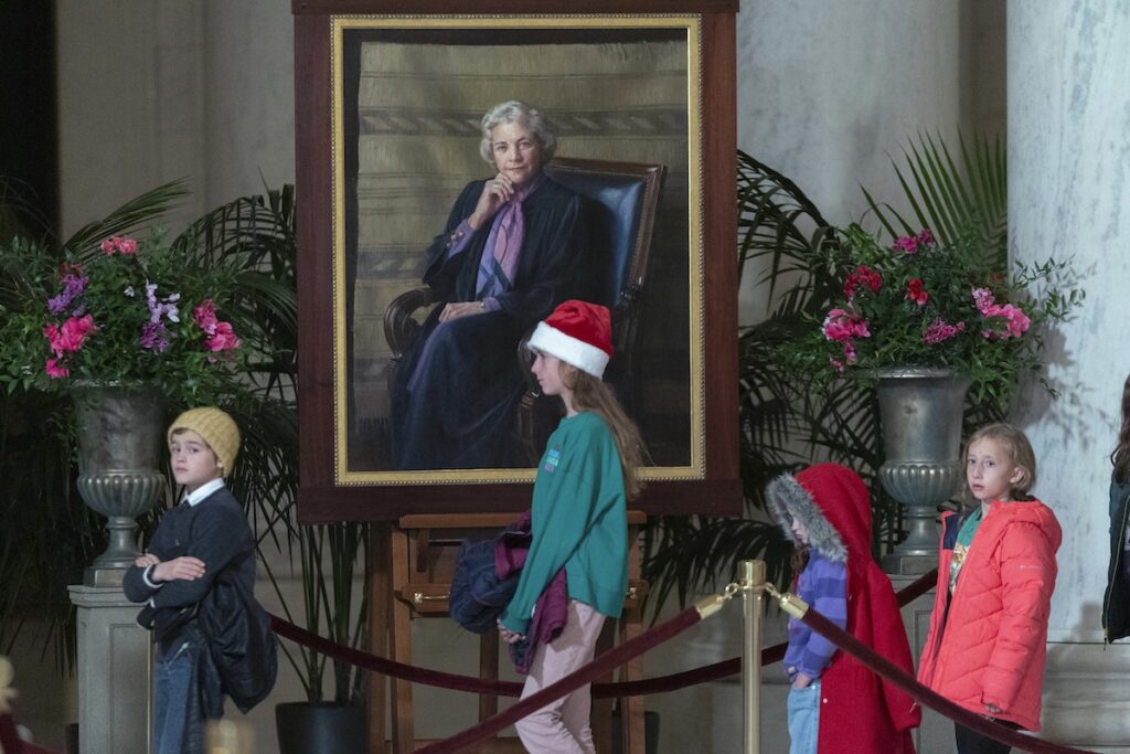 Supreme Court O’Connor Services Children pass by the portait of Sandra Day O'Connor as mourners pay their respects as the flag-draped casket of retired Supreme Court Justice Sandra Day O'Connor lies in the Great Hall at the Supreme Court in Washington, Monday, Dec. 18, 2023. O'Connor, an Arizona native and the first woman to serve on the nation's highest court, died Dec. 1 at age 93.