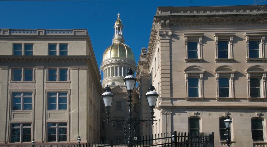 NJ state capitol (For WHYY_Evelyn Tu The New Jersey state capitol building dome as seen through a gap in several buildings.