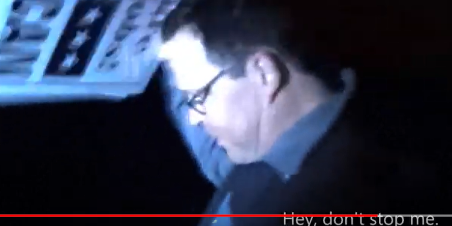 A grainy video of Dana Long lifting a campaign sign in the air. The closed captions read "Hey, don't stop me."