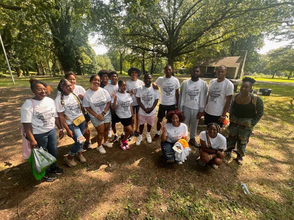 gv-prevention-youth-engagement-2 A group of people pose for a photo in an open clearing with trees.