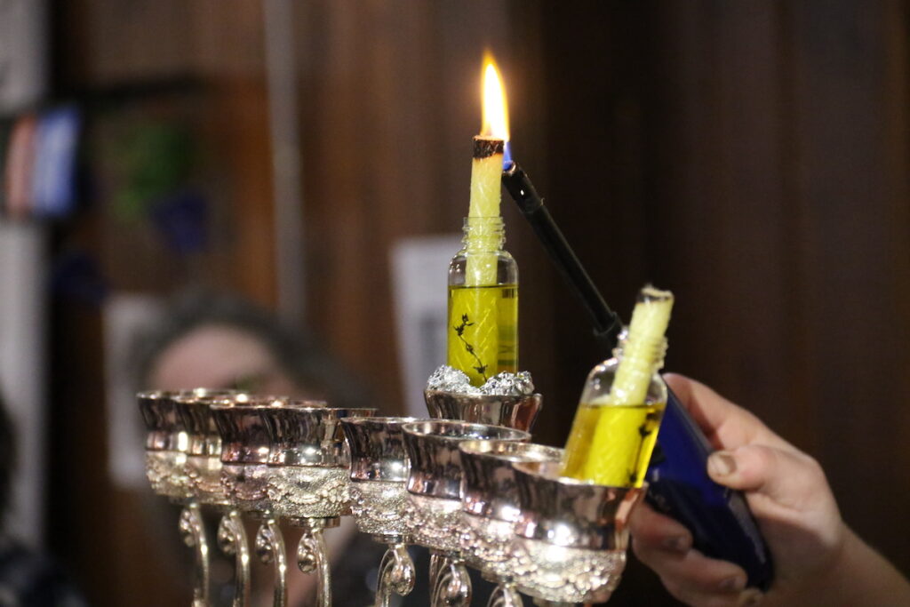 Rabbanit Dasi Fruchter lights the menorah