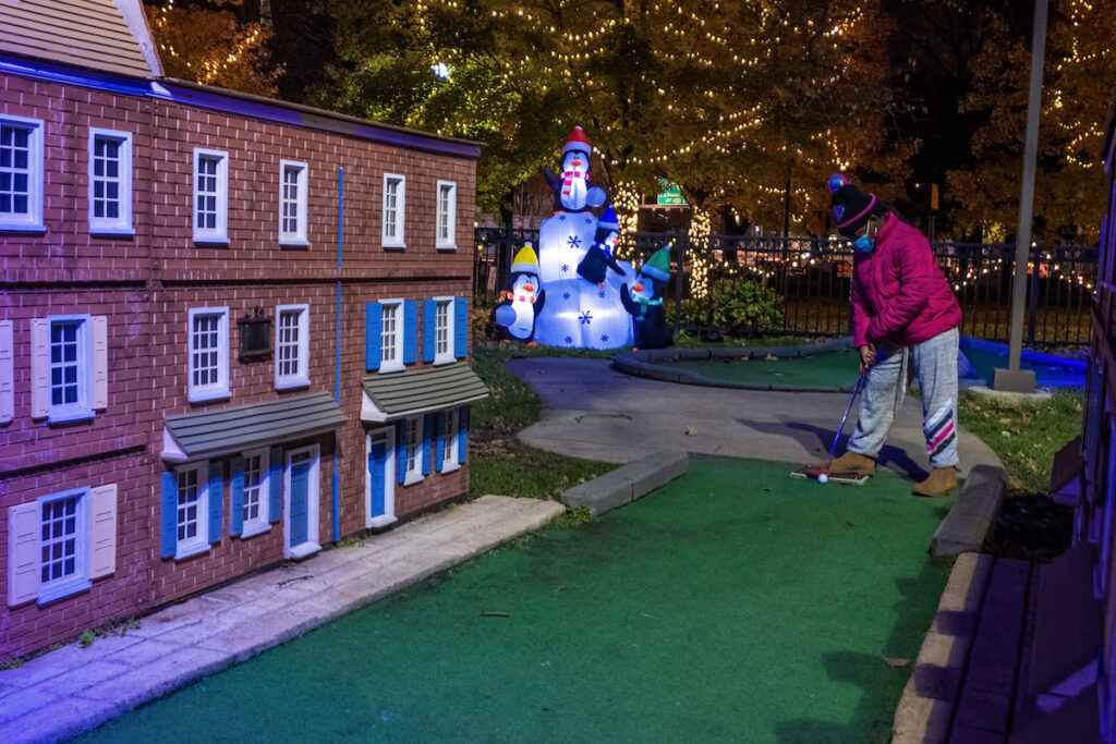 A kid playing mini golf
