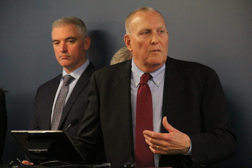 Retired police captain John Darby speaks at a podium