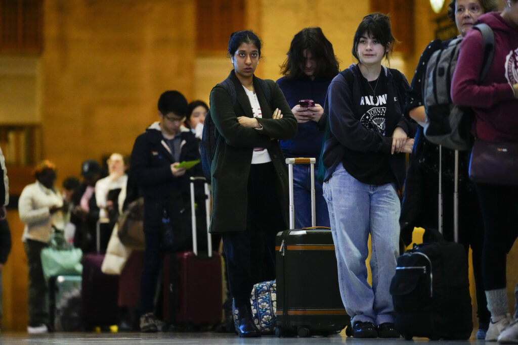 APTOPIX Holiday Travel Travelers wait in line to board an Amtrak train in Philadelphia