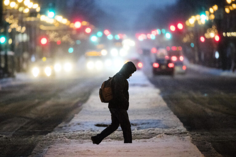 A person crosses South Broad Street during a winter storm in Philadelphia