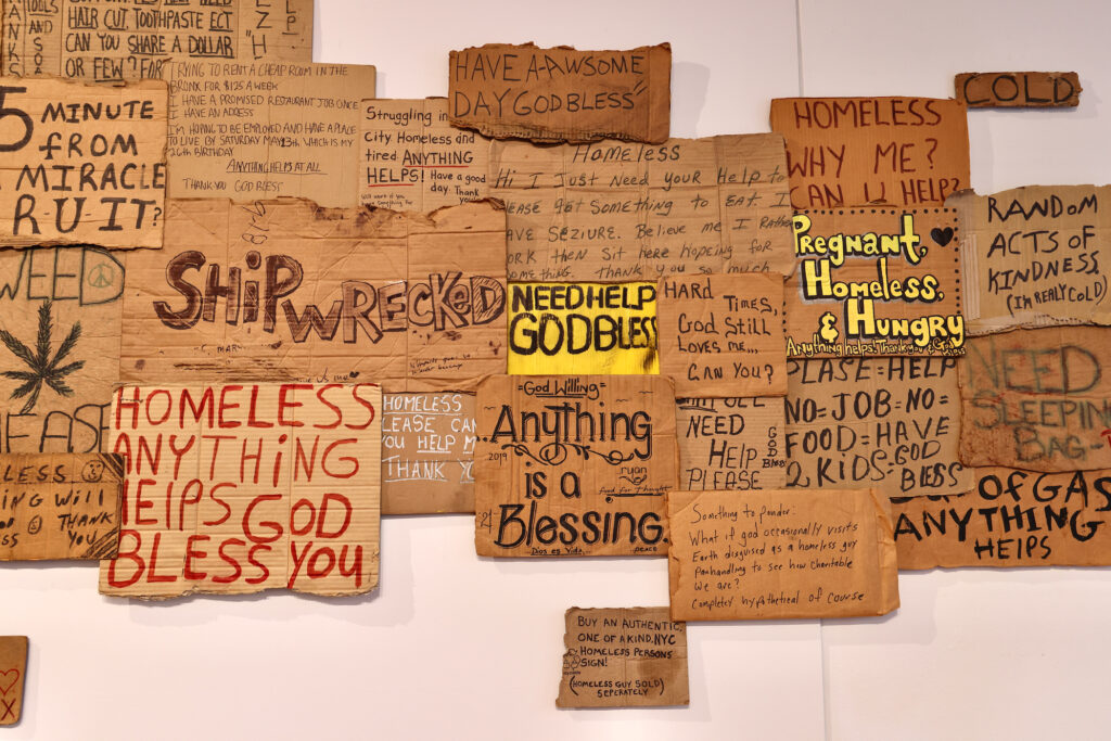 Cardboard signs displayed on a wall