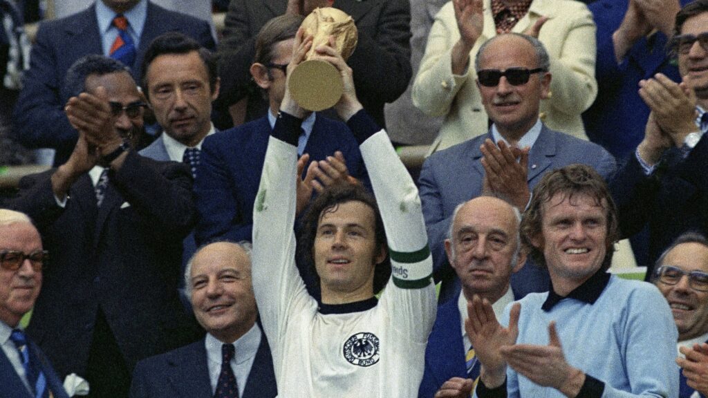 AP24008593397947 (2) West Germany captain Franz Beckenbauer holds up the World Cup trophy after his team defeated the Netherlands by 2-1, in the World Cup soccer final at Munich's Olympic stadium, in West Germany, on Jul. 7, 1974. German soccer great Franz Beckenbauer has died at 78, news agency dpa reports.