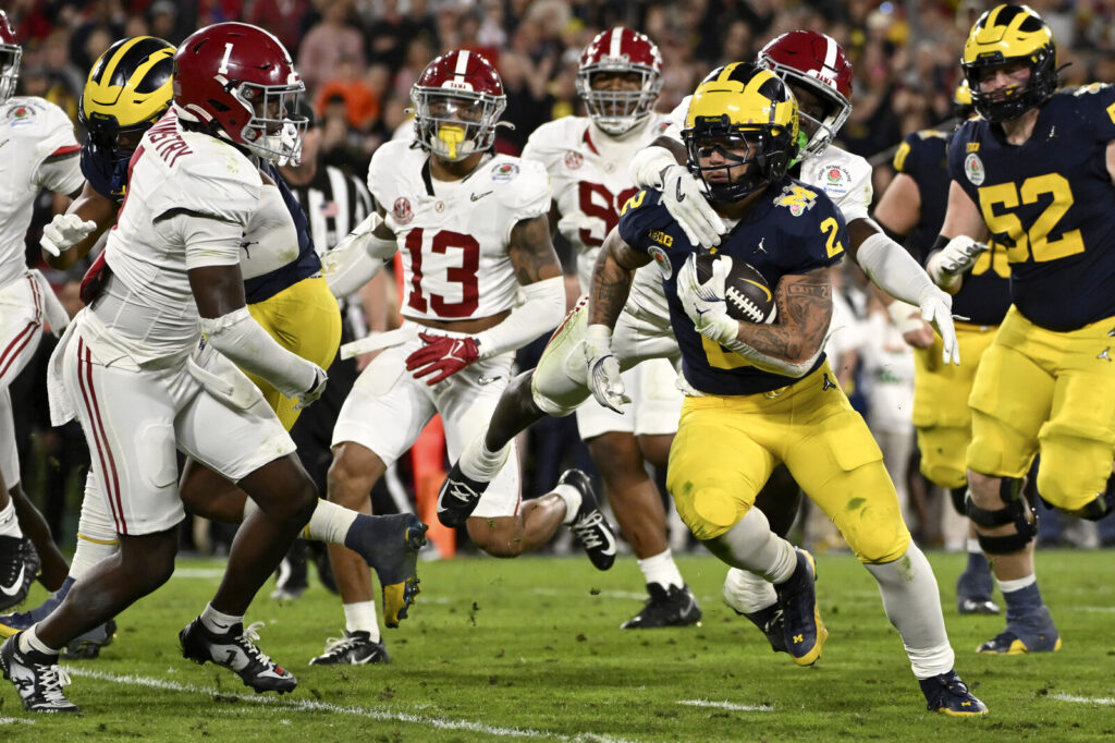 CFP Rose Bowl Football Michigan running back Blake Corum (2) runs in for a touchdown past Alabama defensive back Kool-Aid McKinstry (1) during overtime at the Rose Bowl CFP NCAA semifinal college football game Monday, Jan. 1, 2024, in Pasadena, Calif. (AP Photo/Kyusung Gong)