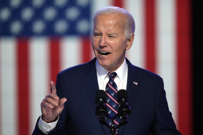 Biden speaking in front of the backdrop of a U.S. flag