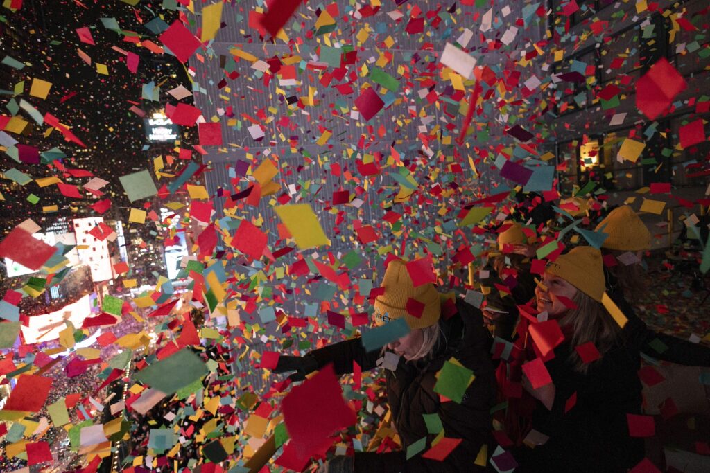 New Years New York Times Square Alliance volunteers throw confetti as the clock strikes midnight