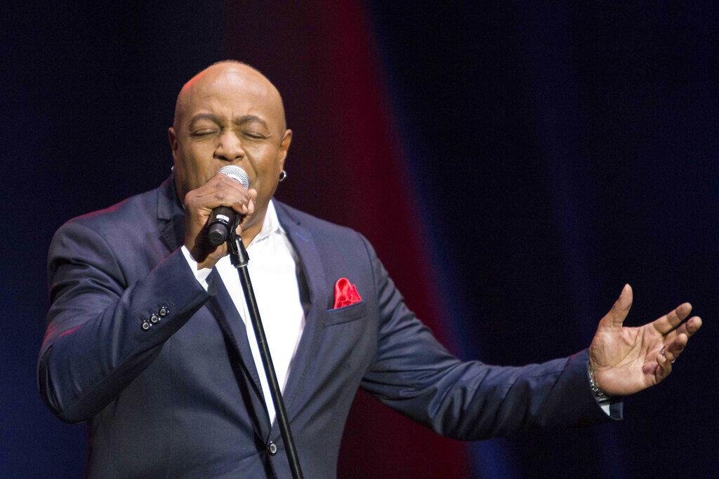 Peabo Bryson sings into a microphone.