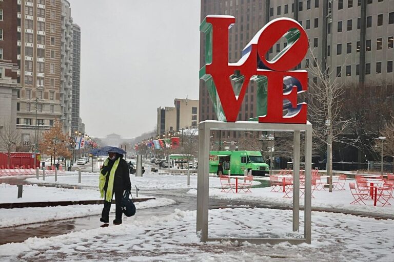 A person walking in Love Park in Philadelphia in the snow