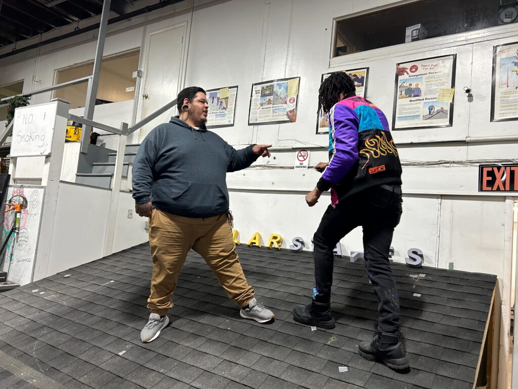 Trainer Moises Morales (left) and Eric Coleman (right) on a model rooftop. (Sophia Schmidt/WHYY)