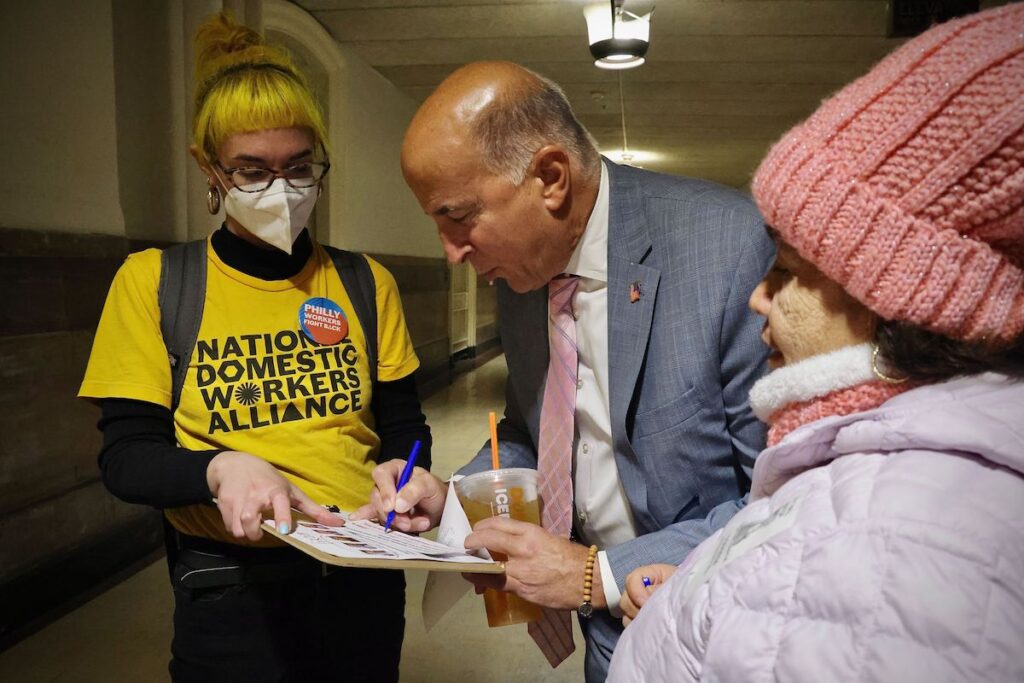 workers-cc-pledge-2 Councilmember Mark Squilla signs a pledge to support workers as members of the Domestic Workers Alliance look on.