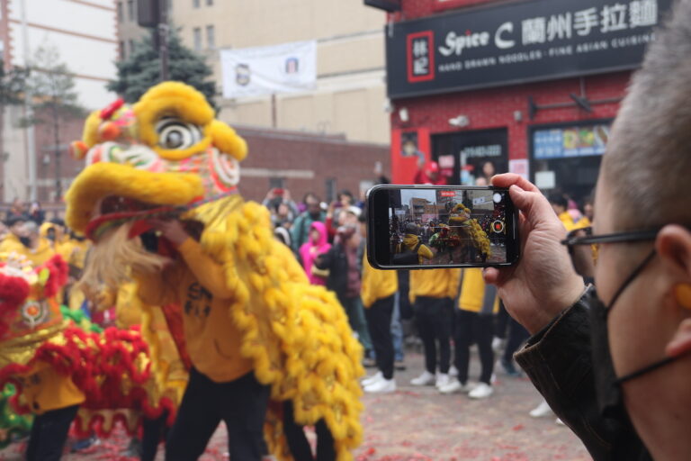 Attendees made sure to document their cherished memories of Sunday's Lunar New Year Parade. (Cory Sharber/WHYY)