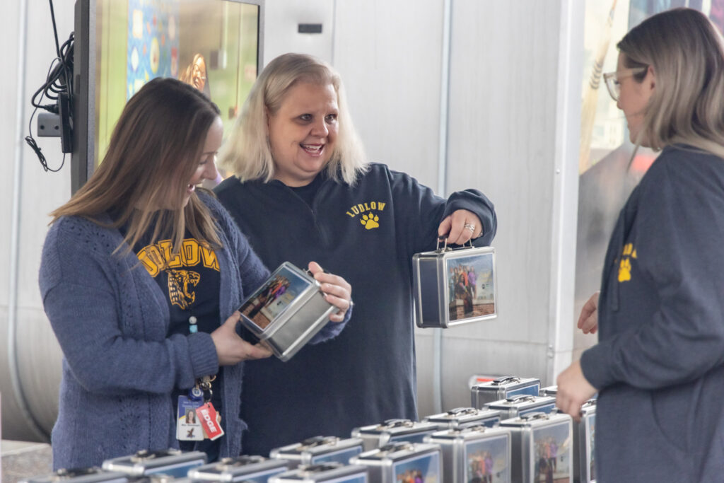 Carin Bennicoff, center, holds up a lunchbox