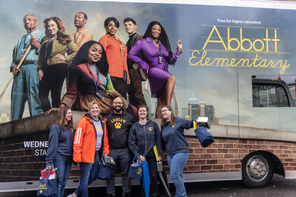 James R. Ludlow School Principal Khary Moody, center, poses in front of the lunchbox truck with excited teachers