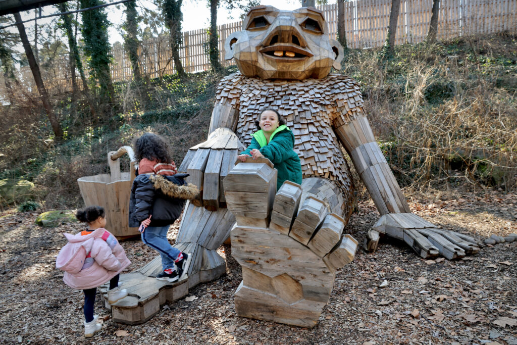 Children clamber on thee feet of the troll sculpture Basse Buller