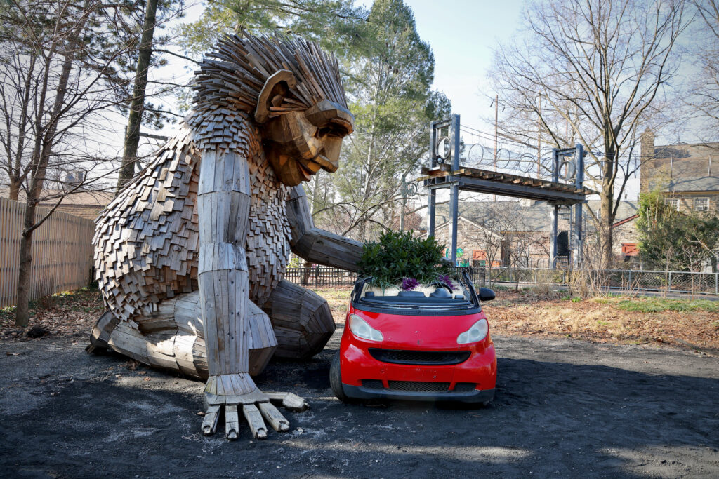 2024 02 01-e lee-philadelphia zoo-thomas dambo trolls rosa sunfinger The troll sculpture Rosa Sunfinger tends to plants growing in a small car.