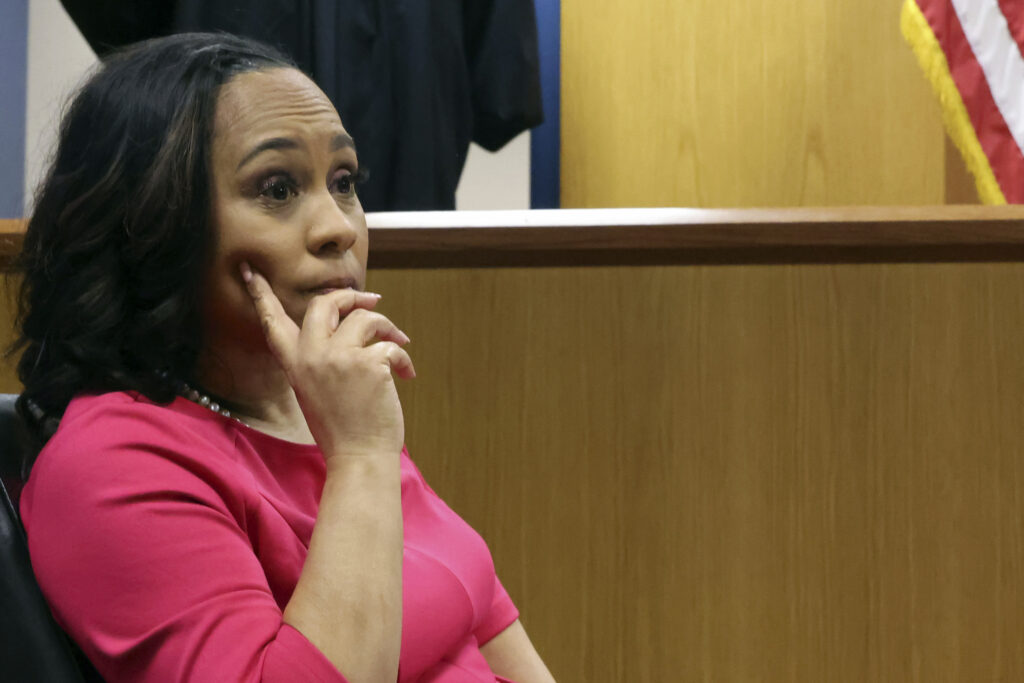 Georgia Election Indictment Fulton County District Attorney Fani Willis sits in the stand as Fulton County Superior Judge Scott McAfee steps away for a break during a hearing on the Georgia election interference case, Thursday, Feb. 15, 2024, in Atlanta. The hearing is to determine whether Willis should be removed from the case because of a relationship with Nathan Wade, special prosecutor she hired in the election interference case against former President Donald Trump. (Alyssa Pointer/Pool Photo via AP)