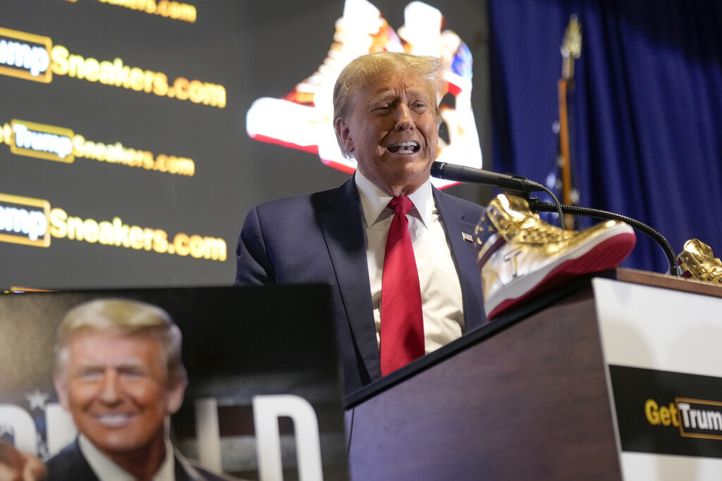 Election 2024 Trump Trump speaks at a podium with gold sneakers in front of him
