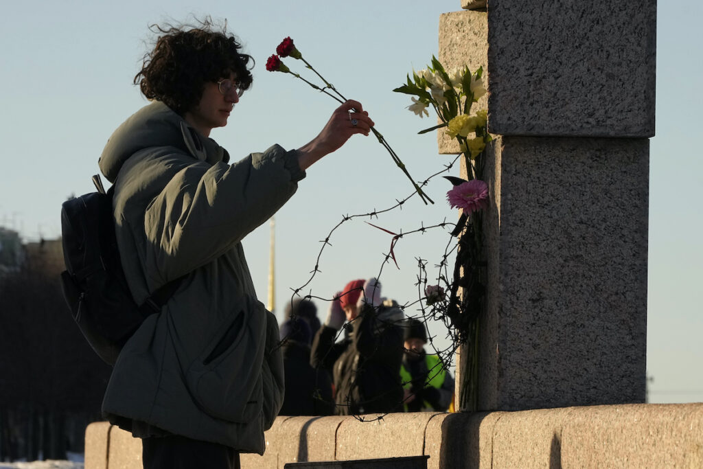 APTOPIX Russia Navalny A woman places flowers as people pay tribute to Alexei Navalny at the Memorial to Victims of Political Repression in St. Petersburg, Russia, Sunday, Feb. 18, 2024. Russians across the vast country streamed to ad-hoc memorials with flowers and candles to pay tribute to Alexei Navalny, the most famous Russian opposition leader and the Kremlin's fiercest critic. Russian officials reported that Navalny, 47, died in prison on Friday.