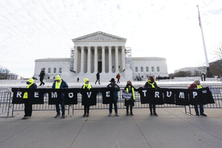 Protesters holding a banner in front of the Supreme COurt that says 'Remove Trump'