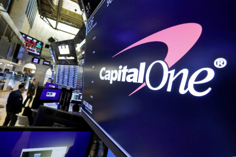 The logo for Capital One Financial is displayed above a trading post on the floor of the New York Stock Exchange.
