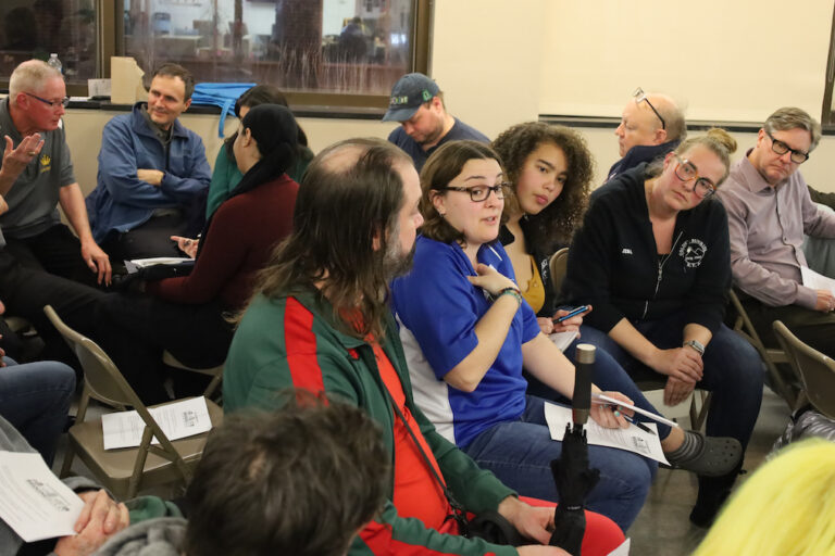 Community members talk together at a Bridging Blocks community discussion about the Mummers