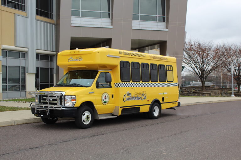 The Conshohocken Cab is parked outside a building