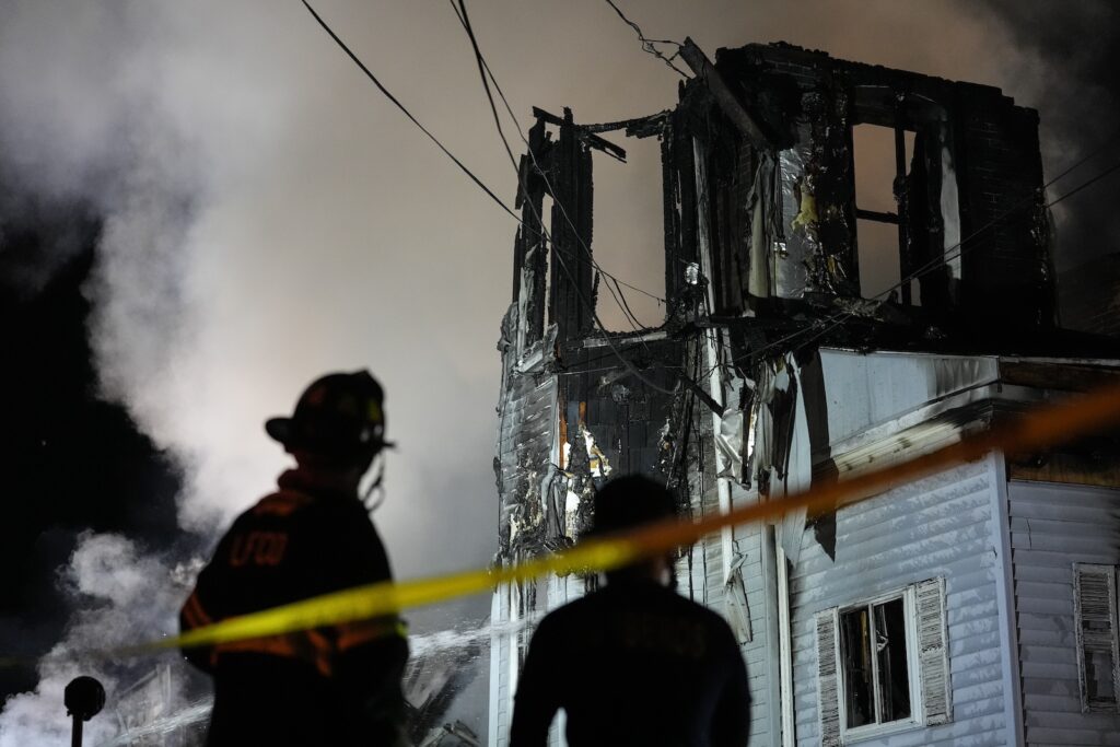 Firefighters work at the scene where two police officers were injured while responding to reported standoff in East Lansdowne, Pa., on Wednesday, Feb. 7, 2024.