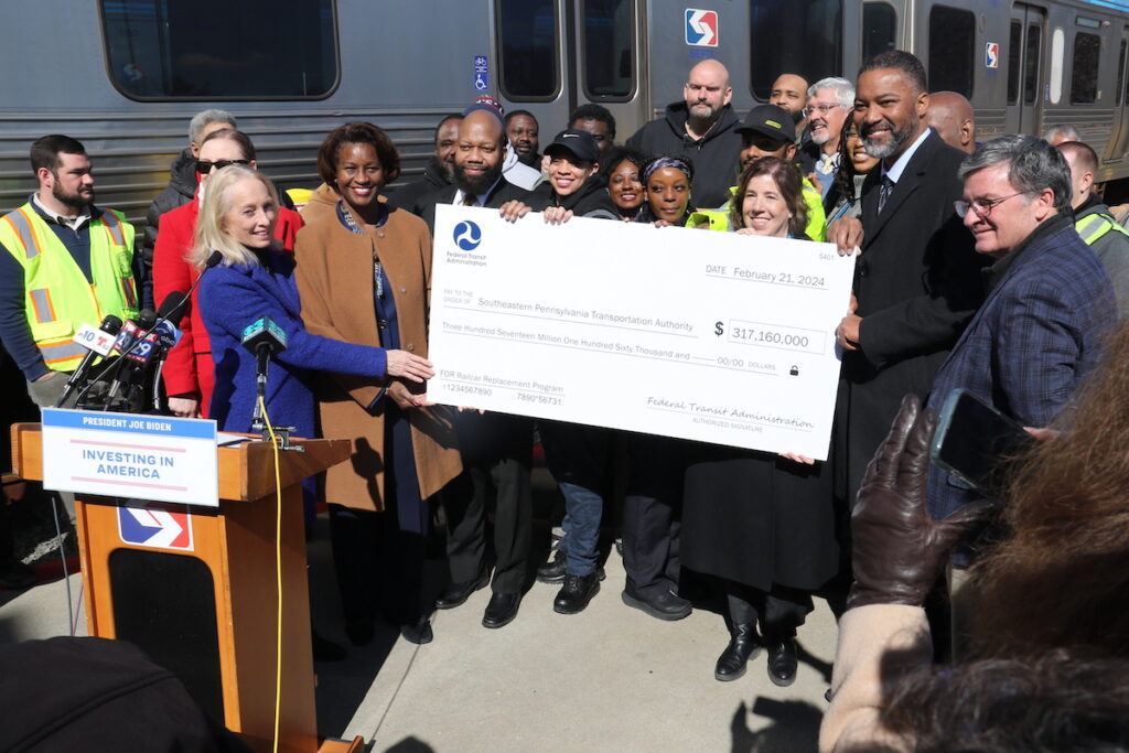 mfl-new-cars-3 Federal, local, and transit officials celebrated, holding a check representing a $317 million grant