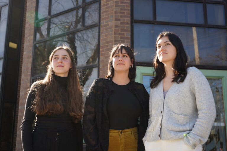 Evie Gentile, Sophie Cloarec and Christina Higashi-Howard pose for a photo together outside of a building