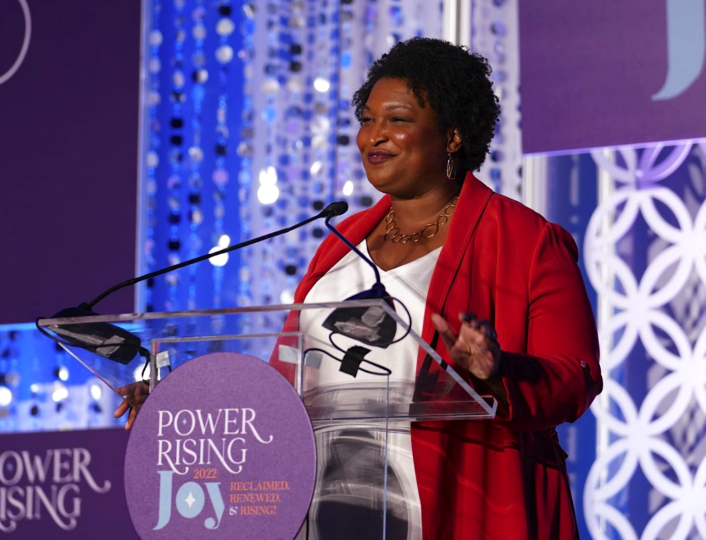 stacey-abrams-power-rising-2022 Stacey Abrams speaking at a podium