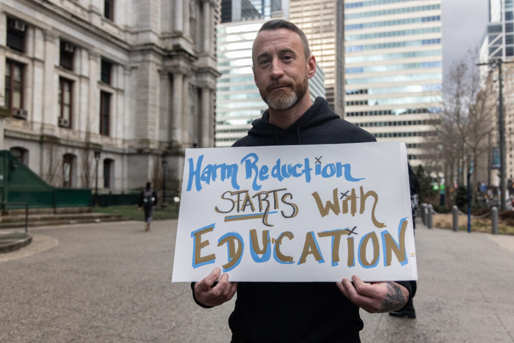 T.J. Erkert with harm reduction advocates at a rally outside City Hall