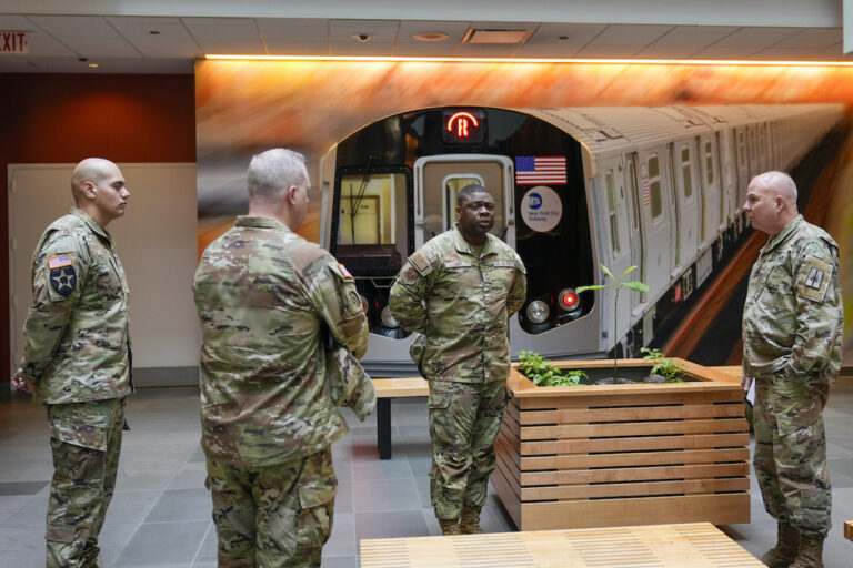 Members of the Armed Forces including the National Guard wait in the lobby of the New York City Mass Transit Authority Rail Control Center before the start of a news conference with Gov. Hochul, Wednesday, March 6, 2024, in New York.