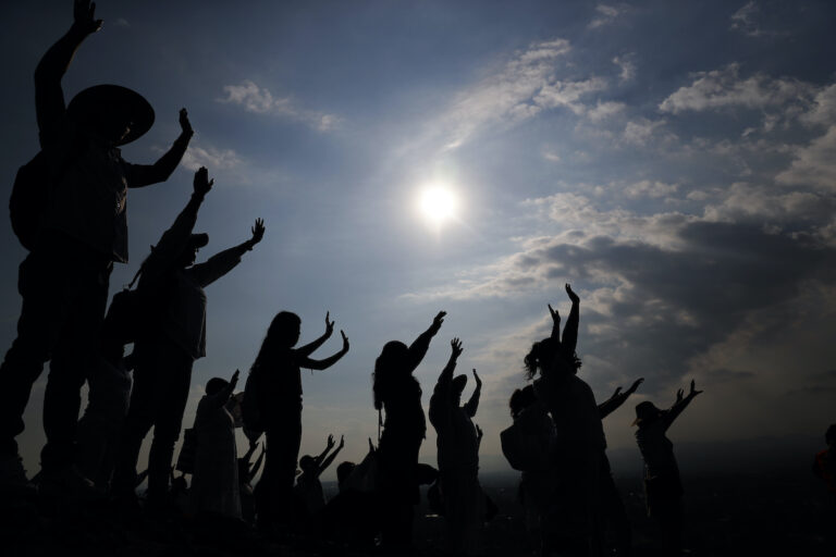 Visitors hold their hands out to receive the sun's energy as they celebrate the Spring equinox atop the Pyramid of the Sun in Teotihuacan, Mexico, Thursday, March 21, 2019.