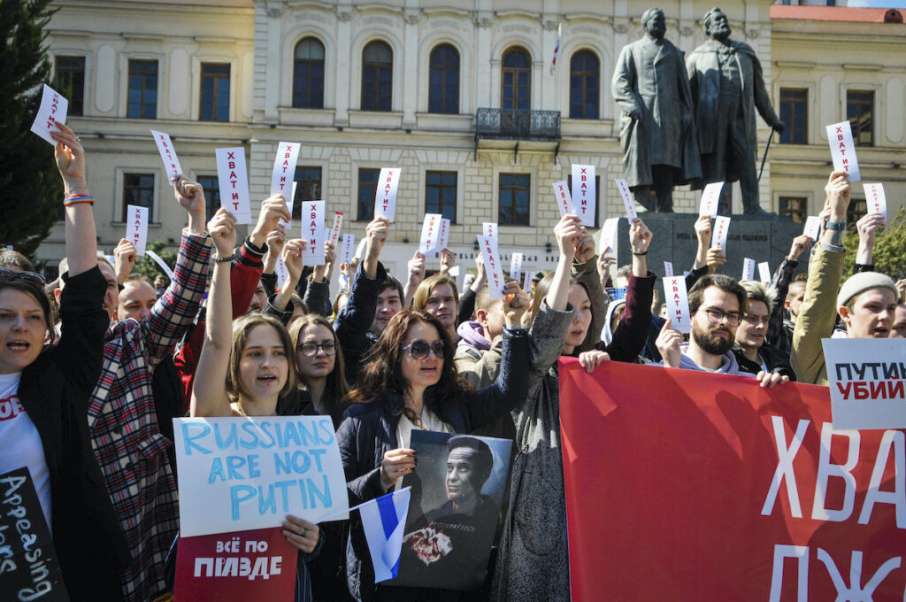Russia Election People hold sheets reading ''enough'' as they protest in downtown Tbilisi, Georgia, Sunday, March 17, 2024. Russians at home and abroad are heading to the polls for a presidential election that is all but certain to extend President Vladimir Putin's rule after he clamped down on dissent.