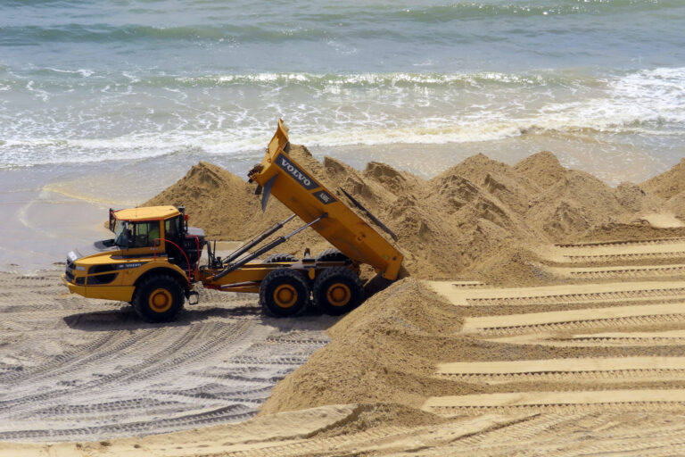 Sand dunes on the beach and a work vehicle