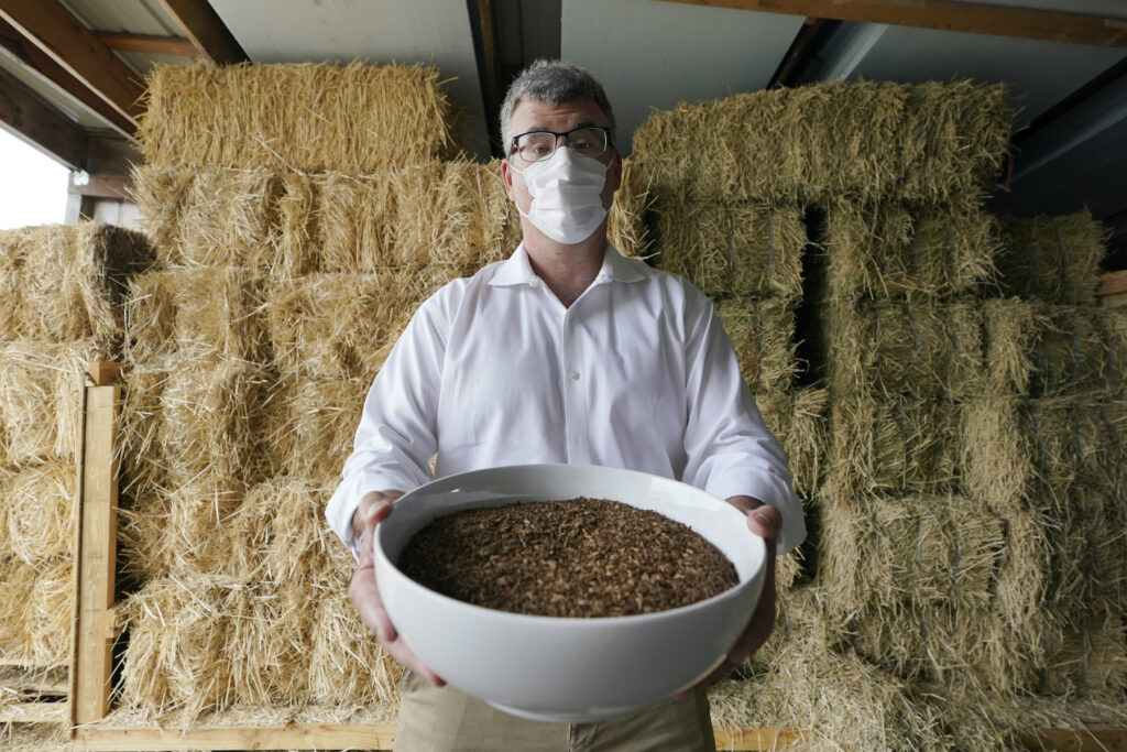 Human Body Composting Micah Truman holding a container filled with soil